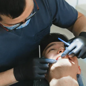 A patient receives dental care from a professional dentist in a clinic setting.