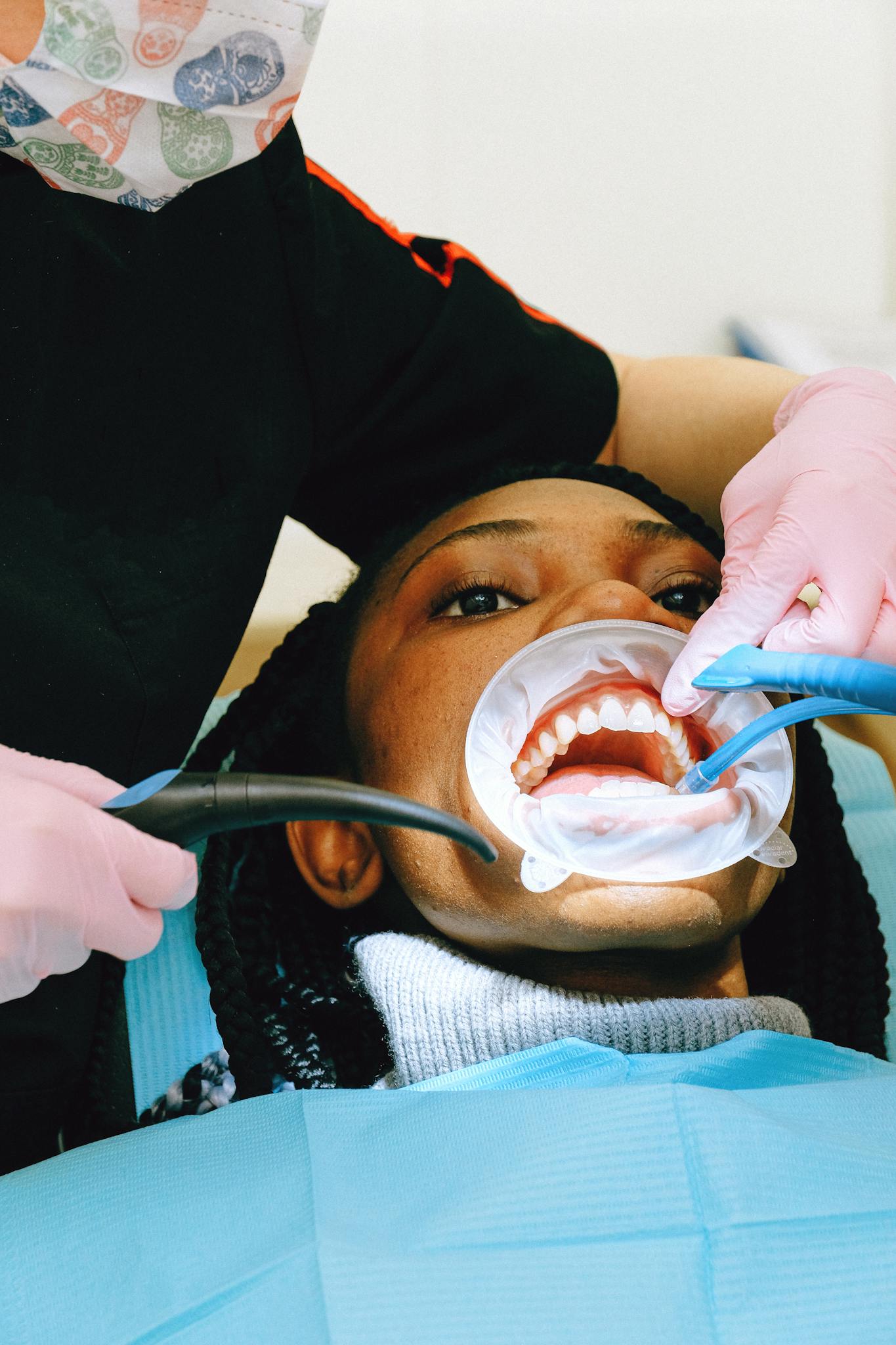 Close-up of a dental practitioner performing a check-up with advanced equipment. Healthcare setting.
